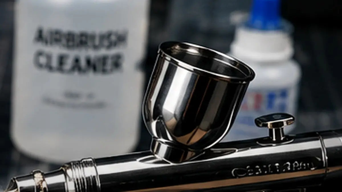 Close-up airbrush on a modeling workbench prepared for cleaning and maintenance