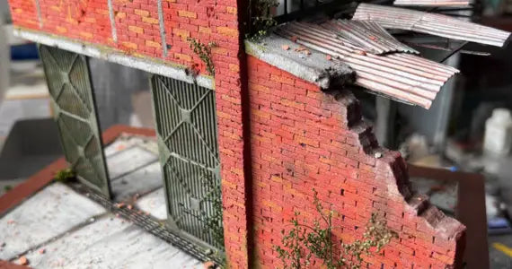 Red brick wall scale building model with weathered texture and greenery growing from cracks for scale modeling tools use