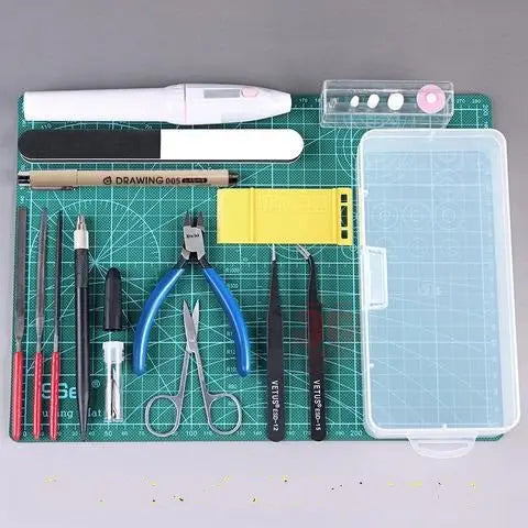 Green cutting mat with grid lines holding white pen blue pliers and black tweezers ideal option for must-have tools needed