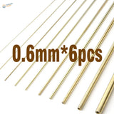 Six 0.6mm brass tubes for scale modeling, diagonal on white background