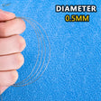 Thin metallic tow cable with 0.5mm diameter held in hand for scale models and scale modeling tools on blue background