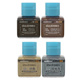 Four square glass bottles of stedicolor modeling stains with bright blue caps labeled in chinese for stedi weathering wash on scale models