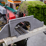 N scale gray stone tunnel portal with arch opening and red and white crossing gates for model railway scenery