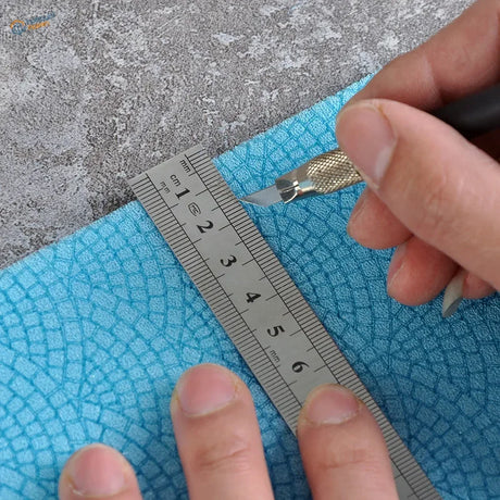Measuring blue textured foam panels with ruler and craft knife for scale modeling