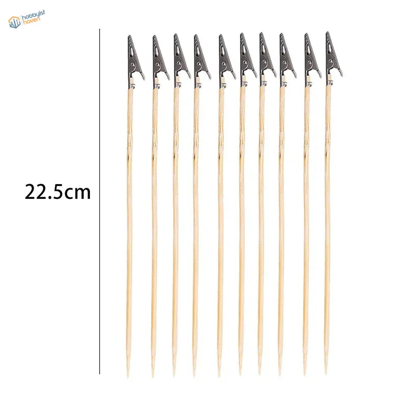 Ten wooden skewers with black alligator clips for scale modeling tools