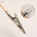 Silver alligator clip with serrated jaws gripping wooden stick, model building tool