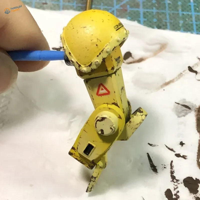 Yellow mini weathering robot model with chipped paint for Cormake mini weathering brushes