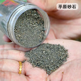 140ml HO/N railway ballast: gray gravel in clear plastic container over palm