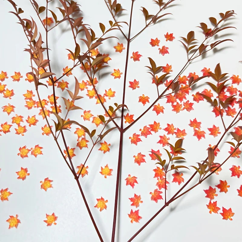 Delicate artificial red maple leaves in orange-yellow autumn arrangement