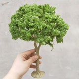 Hand holding 22-30cm artificial tree for scale modeling