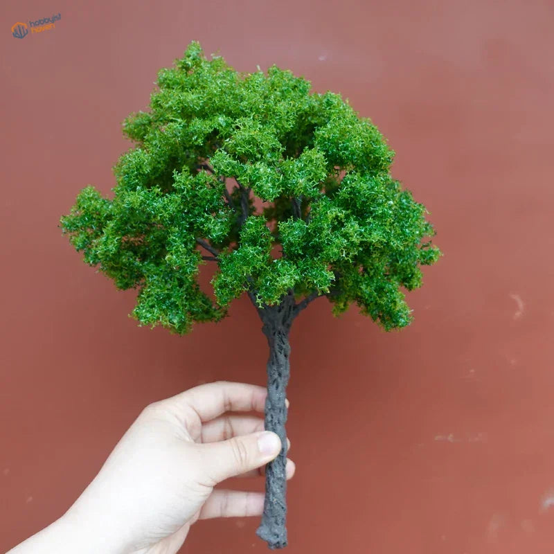 Hand holding 22-30cm artificial tree for scale modeling