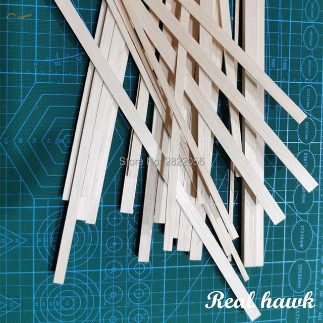 Balsa wood strips scattered on green cutting mat