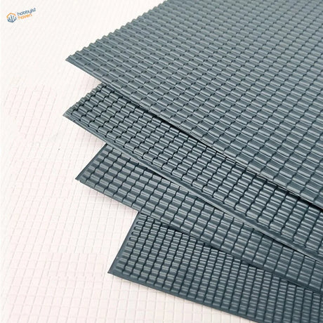Stacked dark gray PVC roof panels with textured grid surface