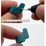 Teal plastic model part with panel lines marked using 6mm transparent scribing tape