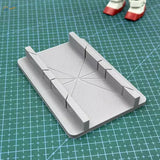 Gray 3D-printed cutting jig with cross-shaped indentation