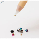 3pcs wax pencils pencil tip hovering over tiny colorful iridescent glass beads