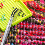 4 tweezers with rubber tips set holding rhinestones on green tray