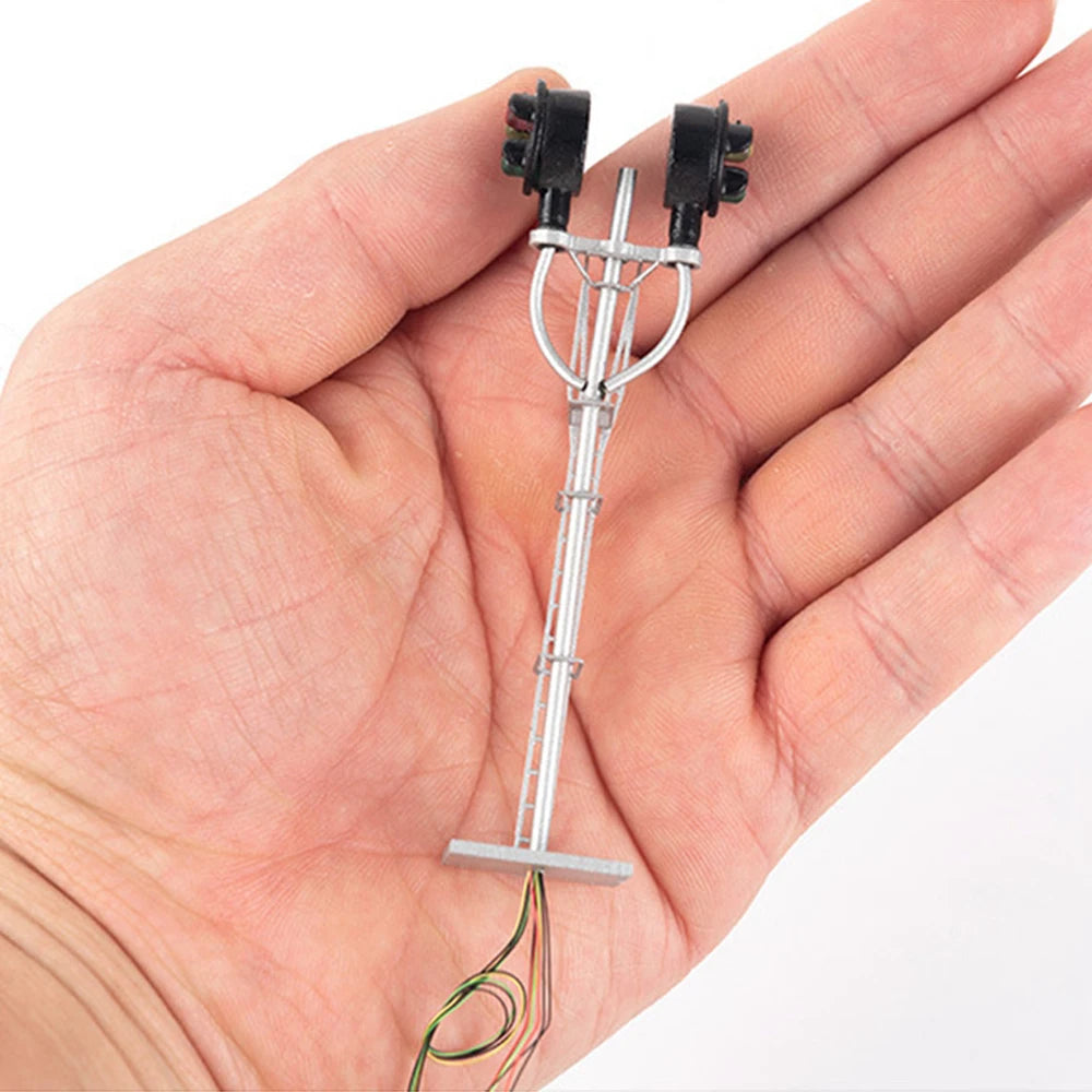Double-head HO scale LED searchlight signal held in a hand for size
