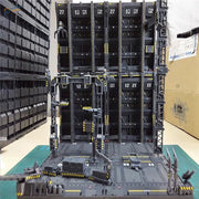 Black plastic Gundam mechanical base with yellow hazard stripes and numbered compartments