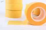 5 pieces masking tape: bright yellow rolls, one unrolled strip flat
