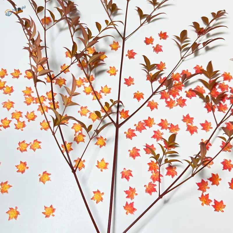 Delicate artificial red maple leaves in orange-yellow autumn arrangement