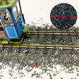 Blue green model train engine on 50g ballast gravel bag track