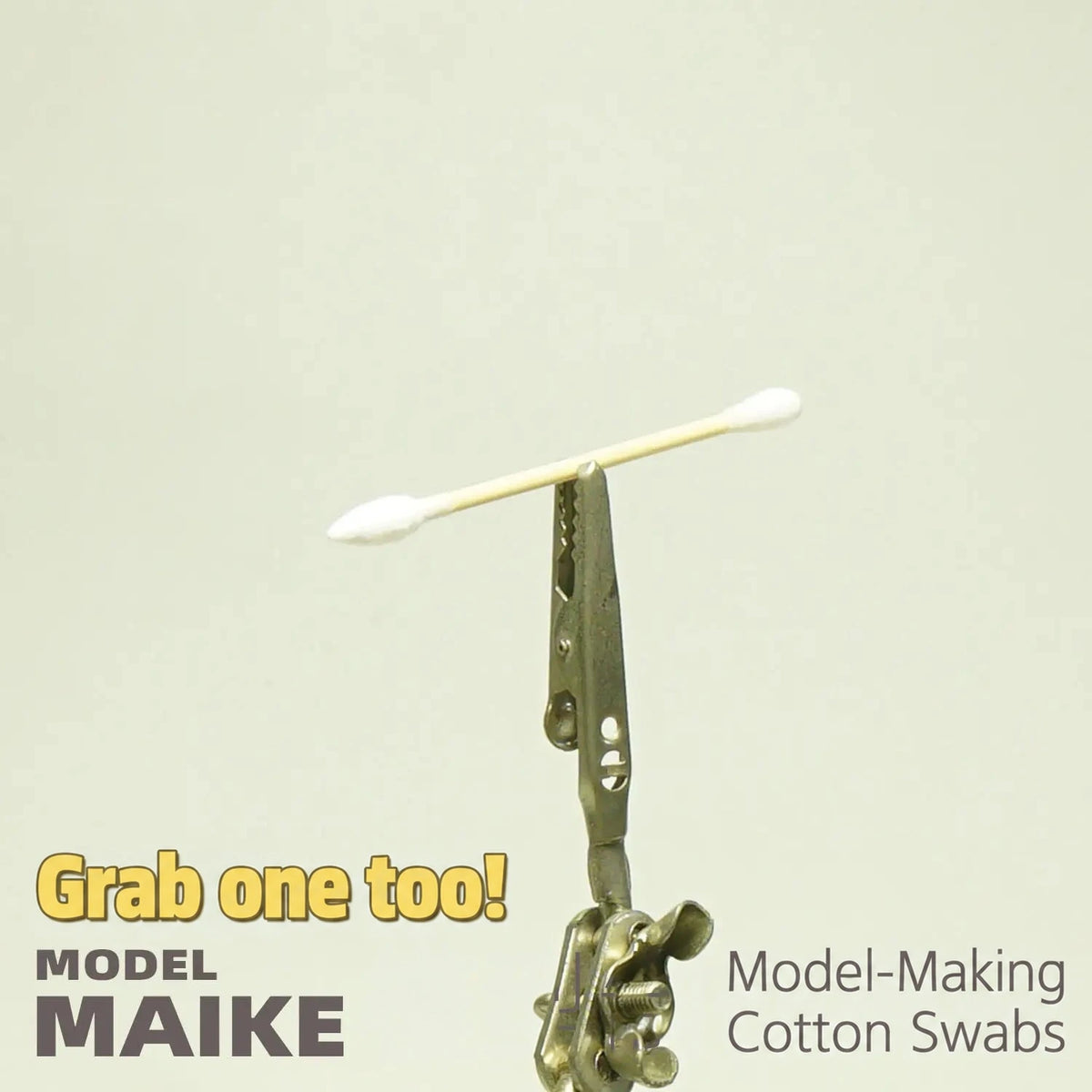 MAIKE double round tip cotton swab held by a clip against a plain background