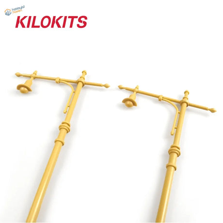 Two yellow plastic 1/35 scale street lamps with crossarms and bell-shaped light fixtures for model building tools