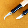 Two precision leather carving tools with black ergonomic handles and silver curved emery file blades from 100Shiki