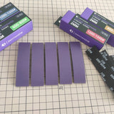 Five purple ultra-thin 2mm sanding sponge strips laid out on a cutting mat next to boxes of 400 to 1500 grit strips