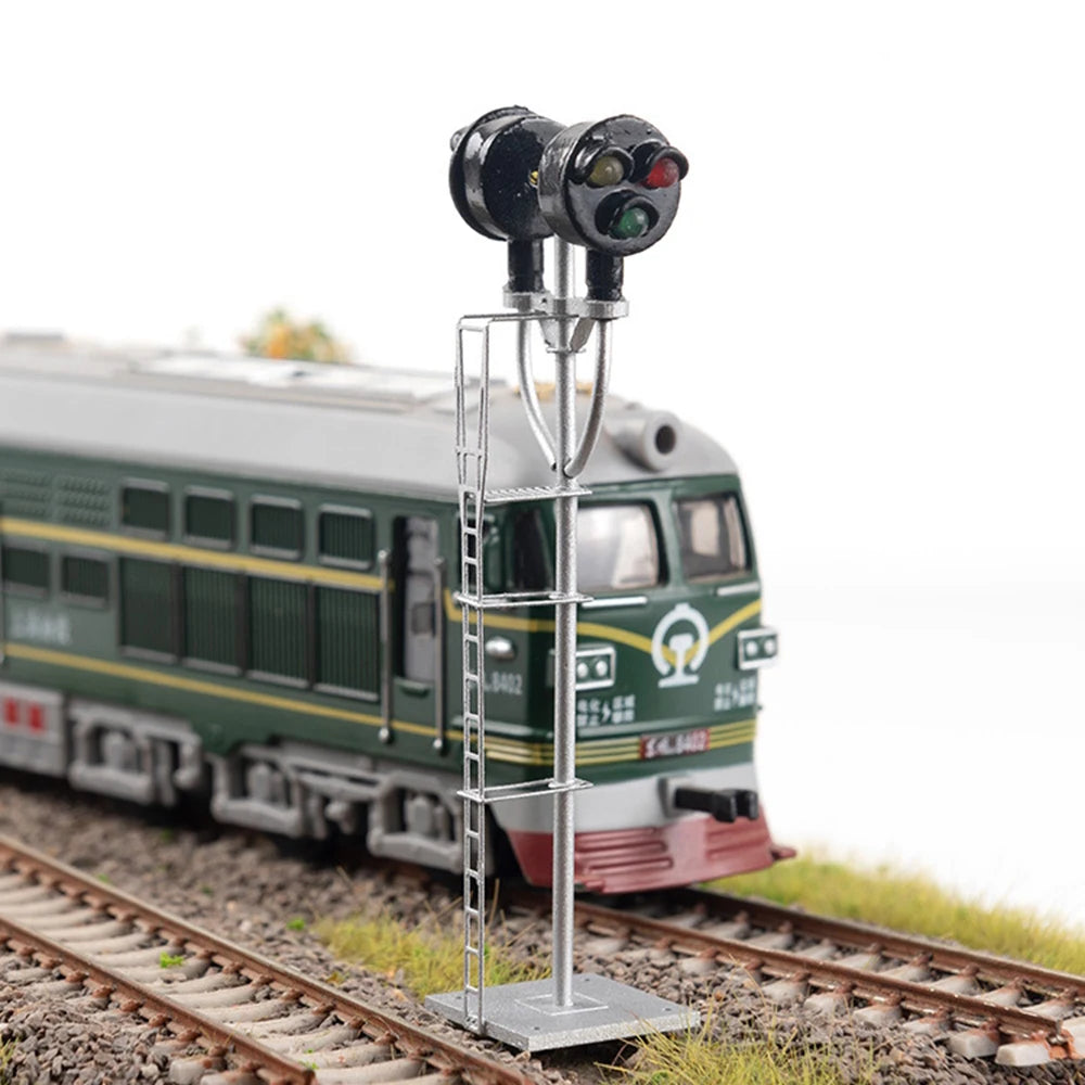 HO scale searchlight signal in front of a green diesel locomotive