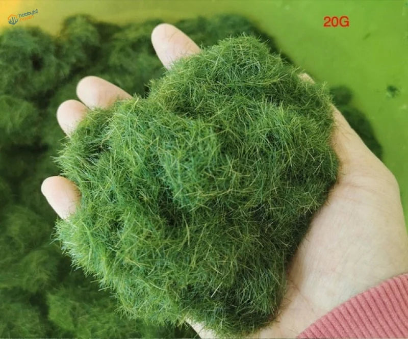 Hand holding 8mm green static grass fibers mound