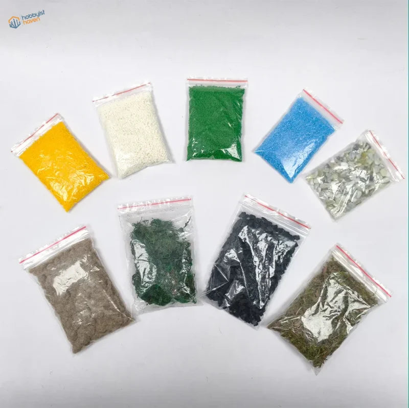 Eight clear plastic bags with colored artificial grass in a nine-piece scenery starter pack for diorama models