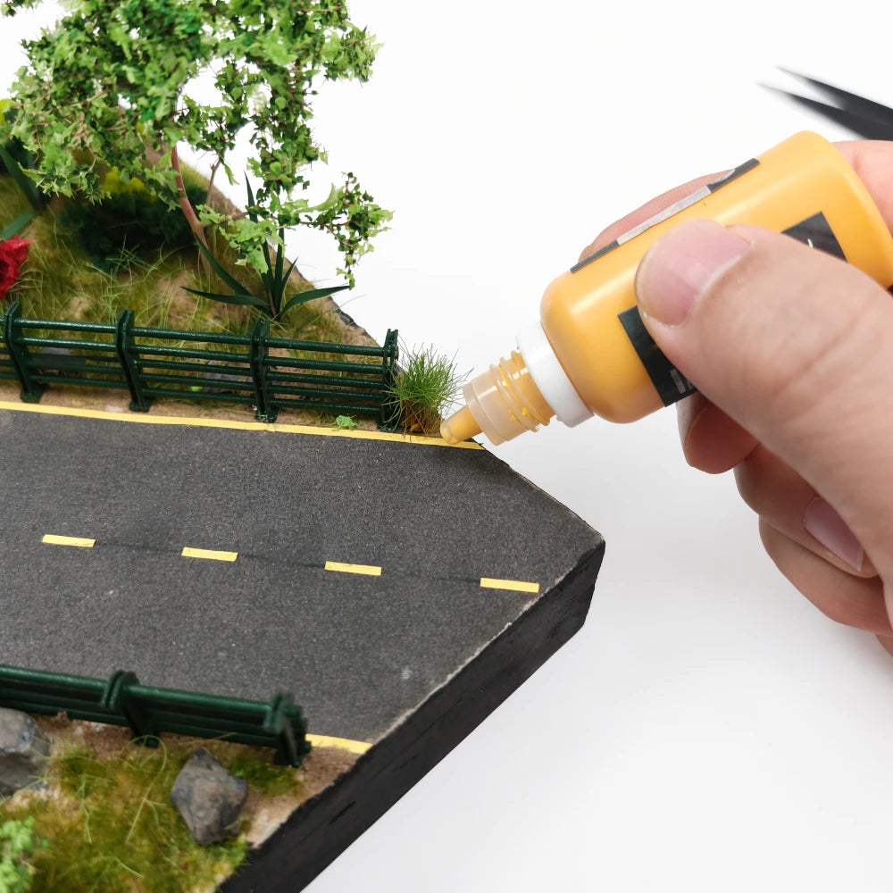 Yellow TEMOD glue applied beside a model road and fence