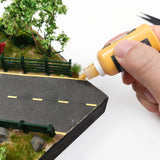 Yellow TEMOD glue applied beside a model road and fence