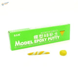 Green rectangular box of ab epoxy putty with yellow and white striped sample for scale modeling tools and scale model use