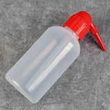 Transparent airbrush cleaning bottle with red nozzle and cap