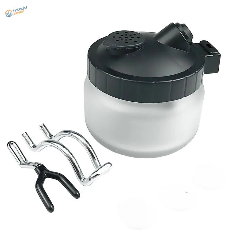 Black translucent airbrush cleaning pot with perforated lid and nozzle