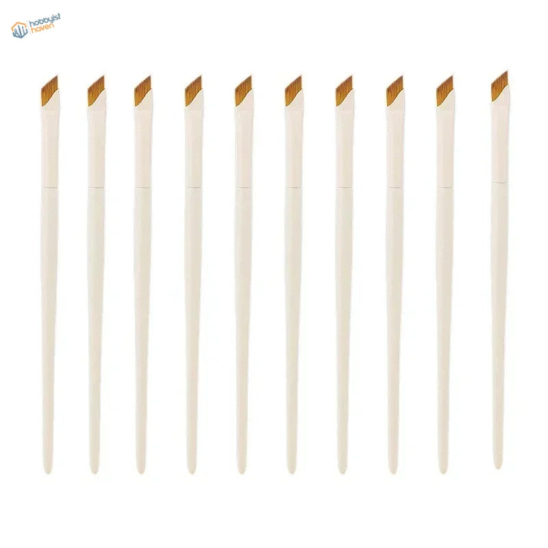 Ten angled liner brushes with white handles and slanted golden-brown bristles