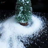 Miniature green Christmas tree dusted with artificial snow powder