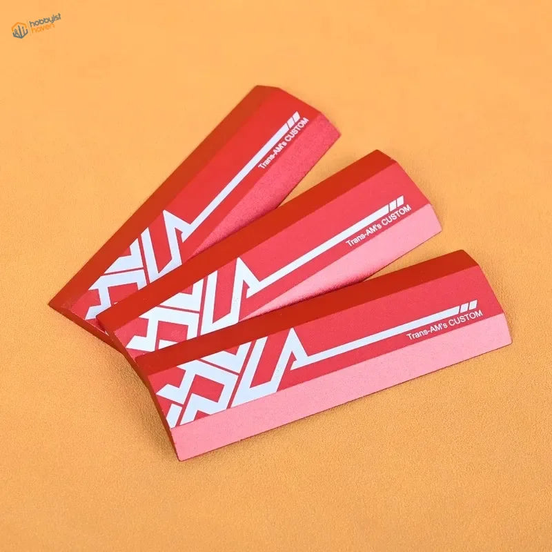 Red and pink beveled edge sanding plates with Trans-Air custom geometric patterns