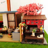 Scale model cherry tree over Japanese oden stall with red sign