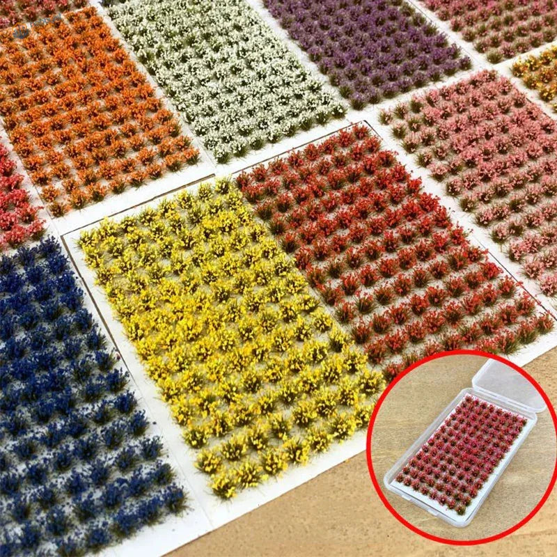 Colorful grass patches in clear plastic container with miniature red model plants