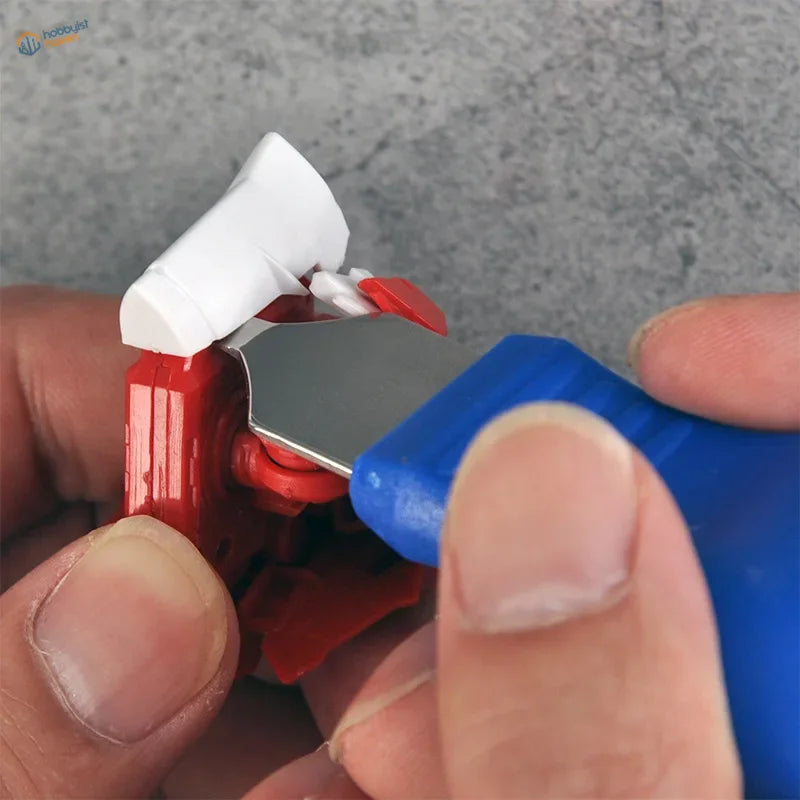 Cormake parts separator: red white toy robot arm on blue tool