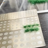 Green static grass tufts on Cormake static grass applicator perforated template