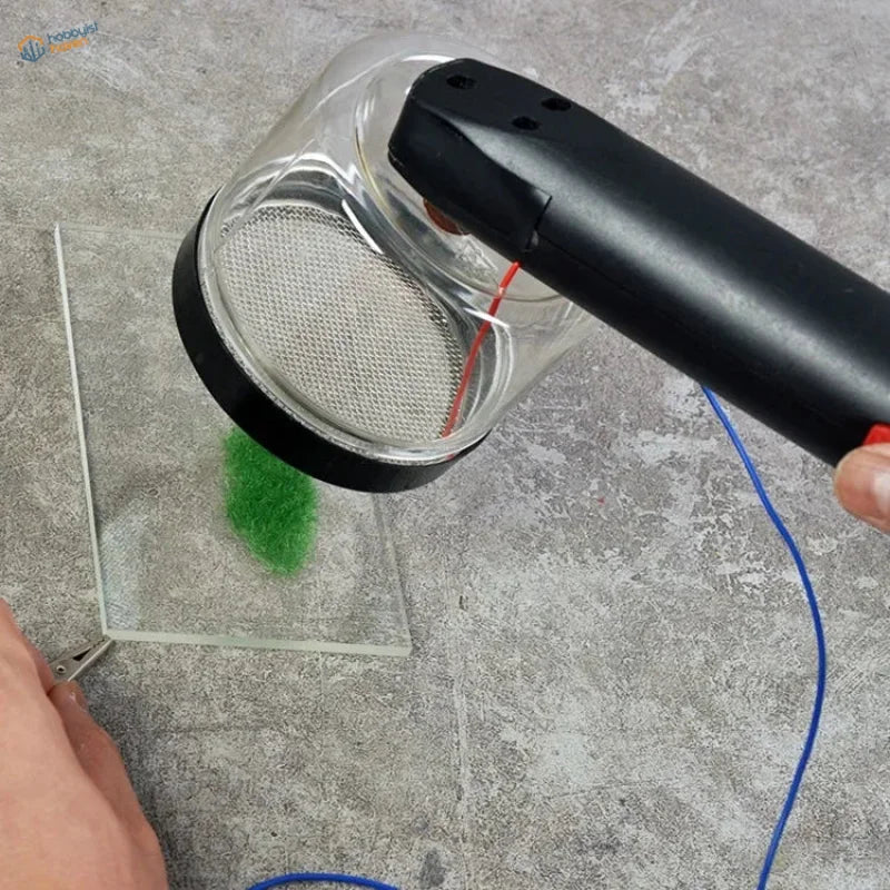 Cormake static grass applicator vacuuming green fuzzy material from glass