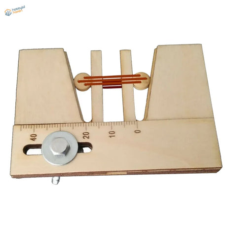 Deadeyes assembly tool: wooden jig holding two deadeyes with aligned rigging lines and an engraved measuring scale