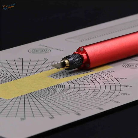 Red DSPIAE craft knife on graph paper for masking tape cutting templates