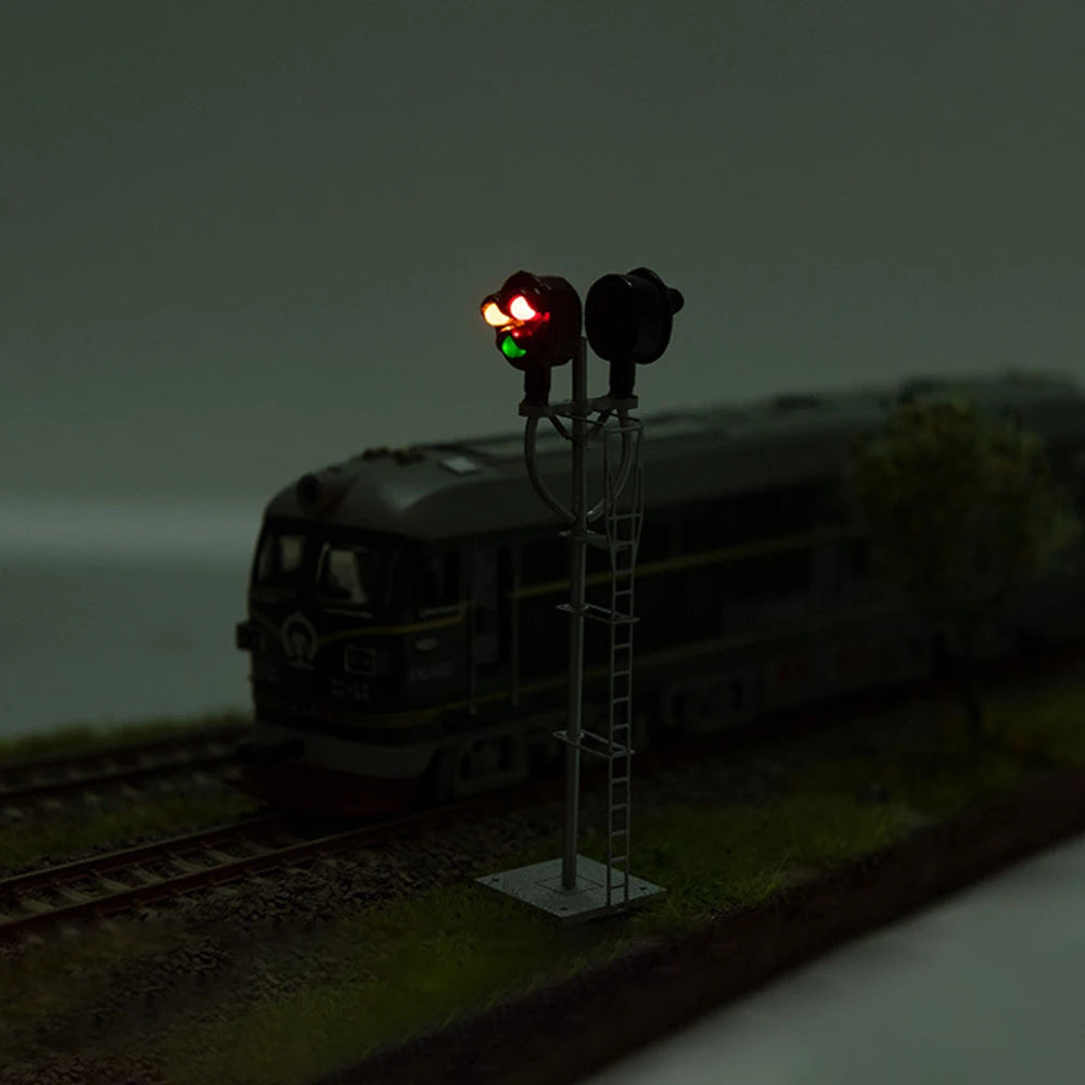 HO scale searchlight signal with red light lit beside a locomotive