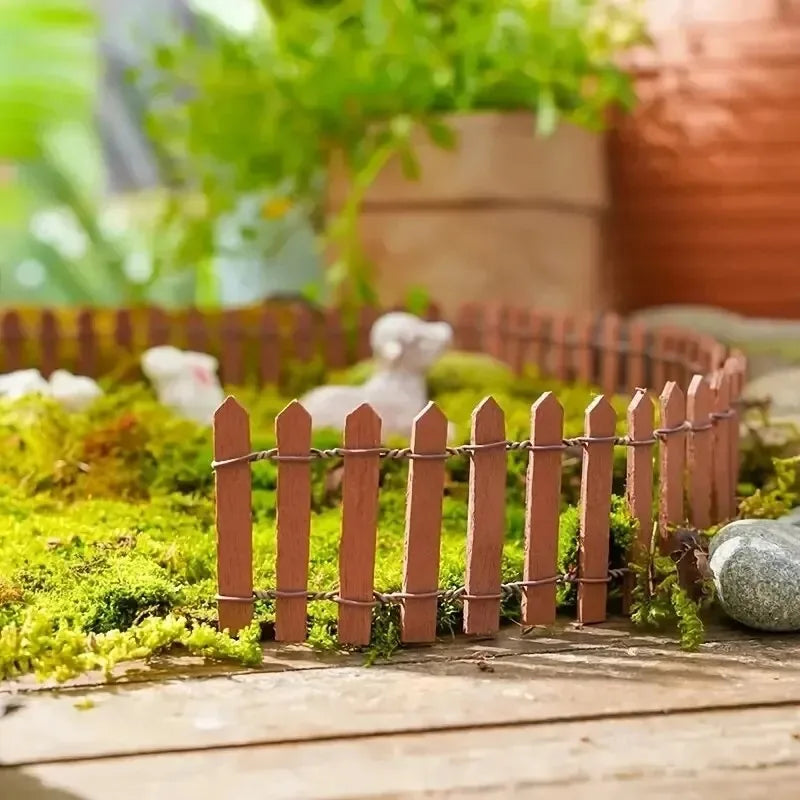Miniature wooden picket fence in terracotta with thin slats and wire bindings for garden and diorama decoration